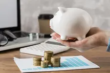 ruka-derzasaa-kopilku-s-diagrammoi-rosta-i-monetami (1).webp